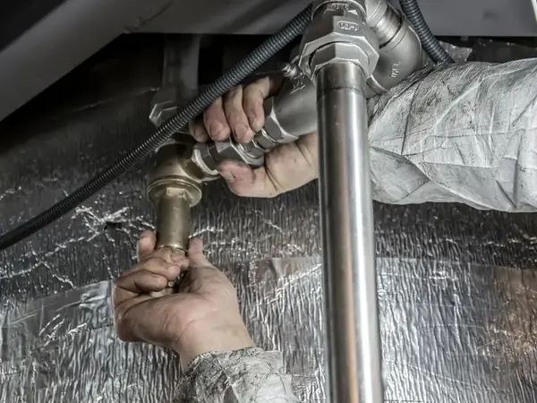 Mains installant des raccords de tuyauterie